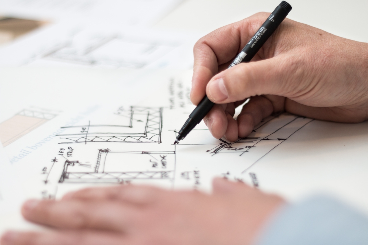 Person drawing an architectural image with a black pen