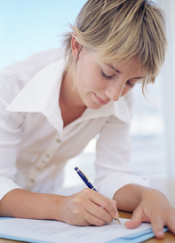 a lady using a pen to fill in some paper work