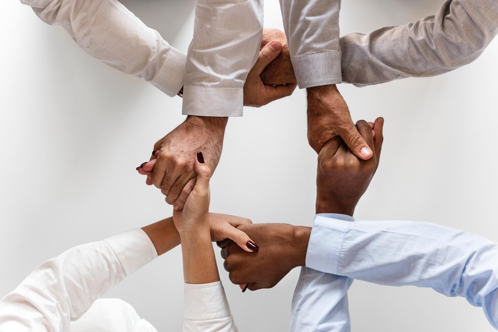 Aerial view of people's holding each other hands creating a circle