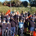 AlargegroupoflocalprimaryschoolstudentsholdingrubbishpickersandrubbishbagscelebratingtheireffortscollectingrubbisharoundalocallakelocatedattheOllieWorrellReserve