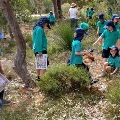 Agroupof12localprimaryschoolstudentswiththeirteacherlookingfornativeplantsintheirschoolgarden