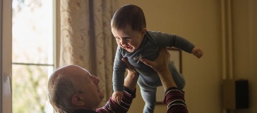 Grandparent holding up grand child 
