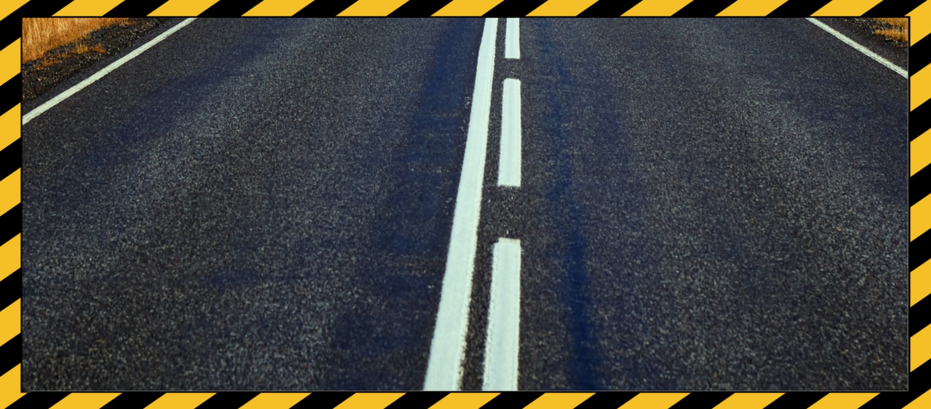 Caution tape surround a bitumen road