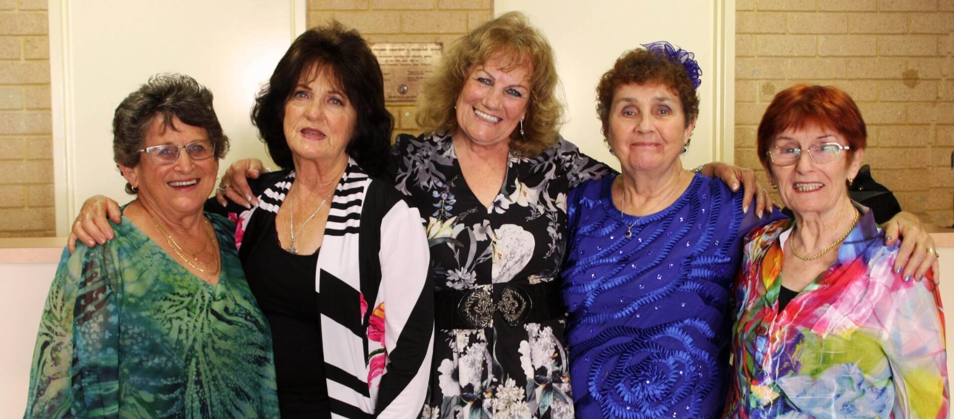 Five ladies with arms around each-other facing the camera smiling during the Seniors Week 2019 Supper Club event