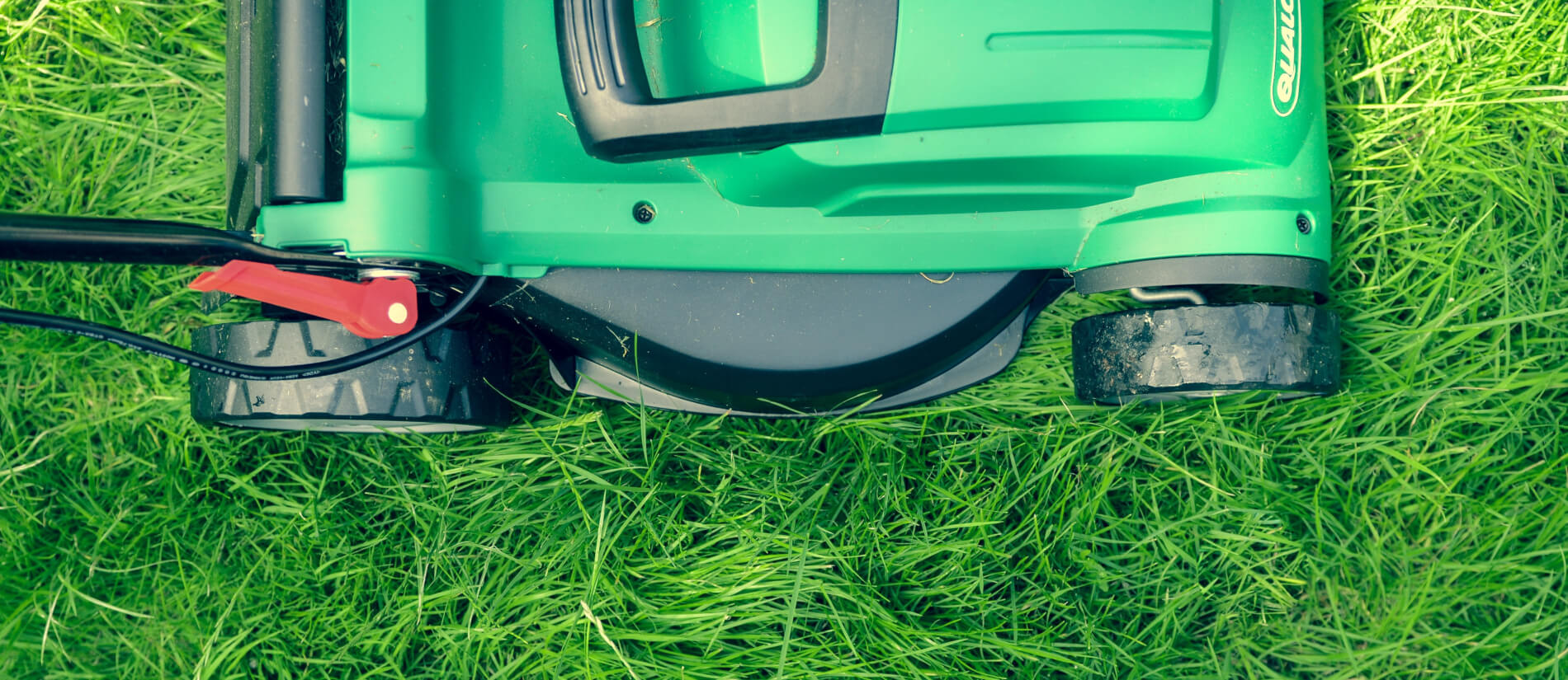 Aerial view of a green lawn mower cutting grass