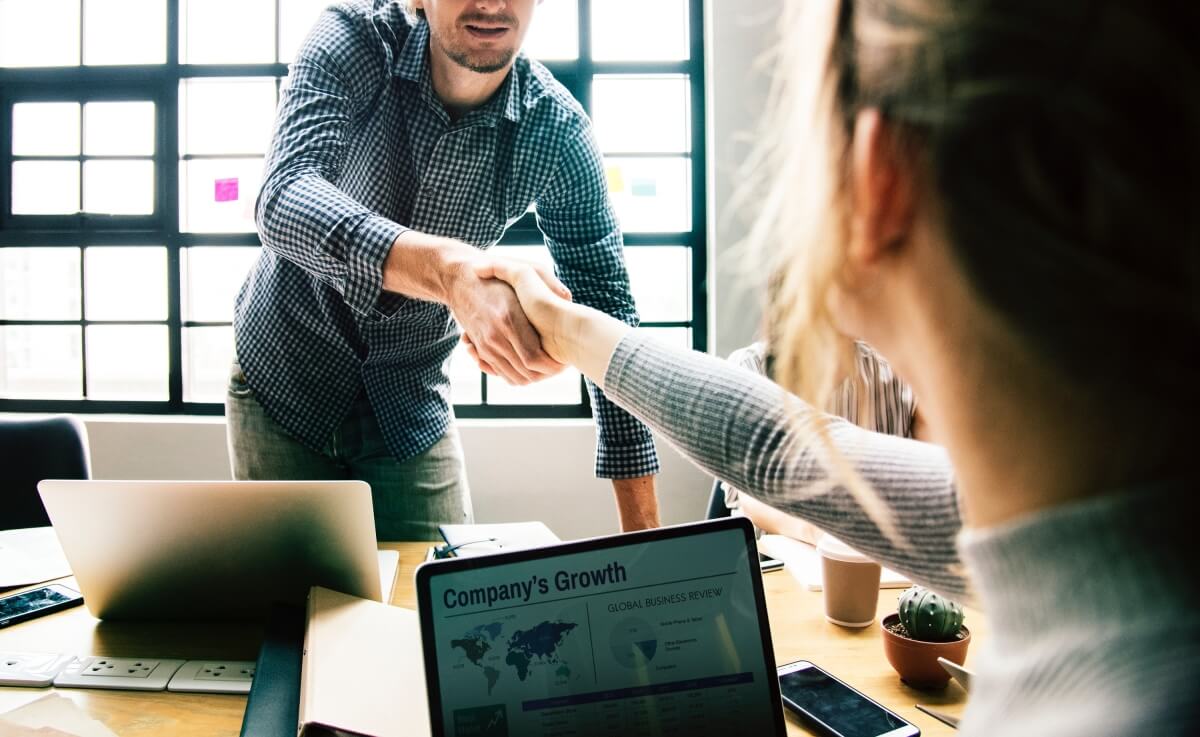 Two colleagues shaking hands in a meeting