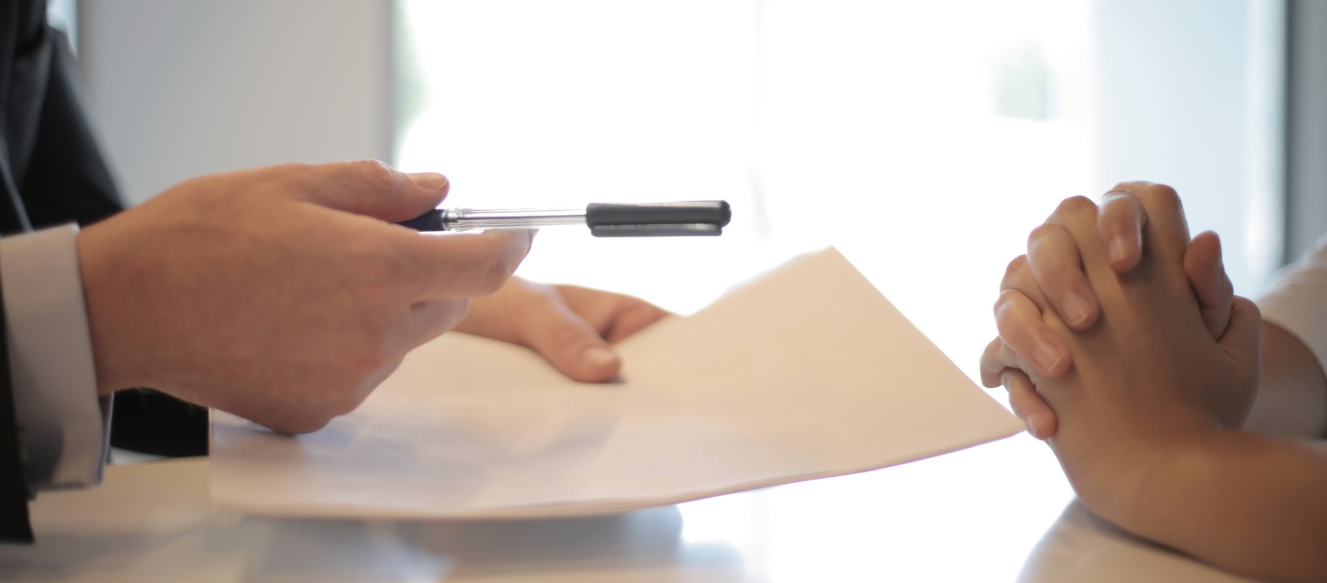 Two people seated at a table discussing a paper 