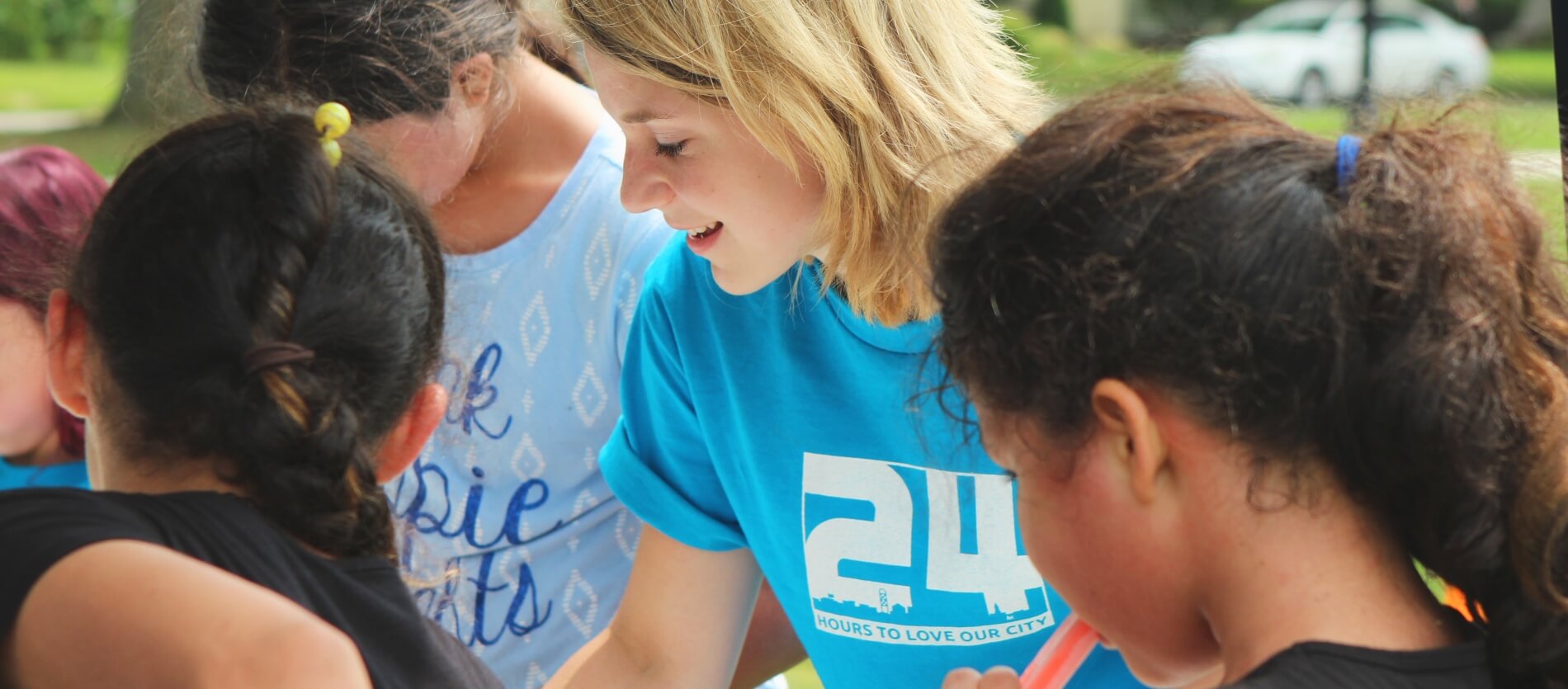 Side profile of an unknown woman volunteer outside in a group.