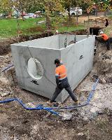 The baffle box being placed into the site by crane and two workers at Stirk Park located in Kalamunda
