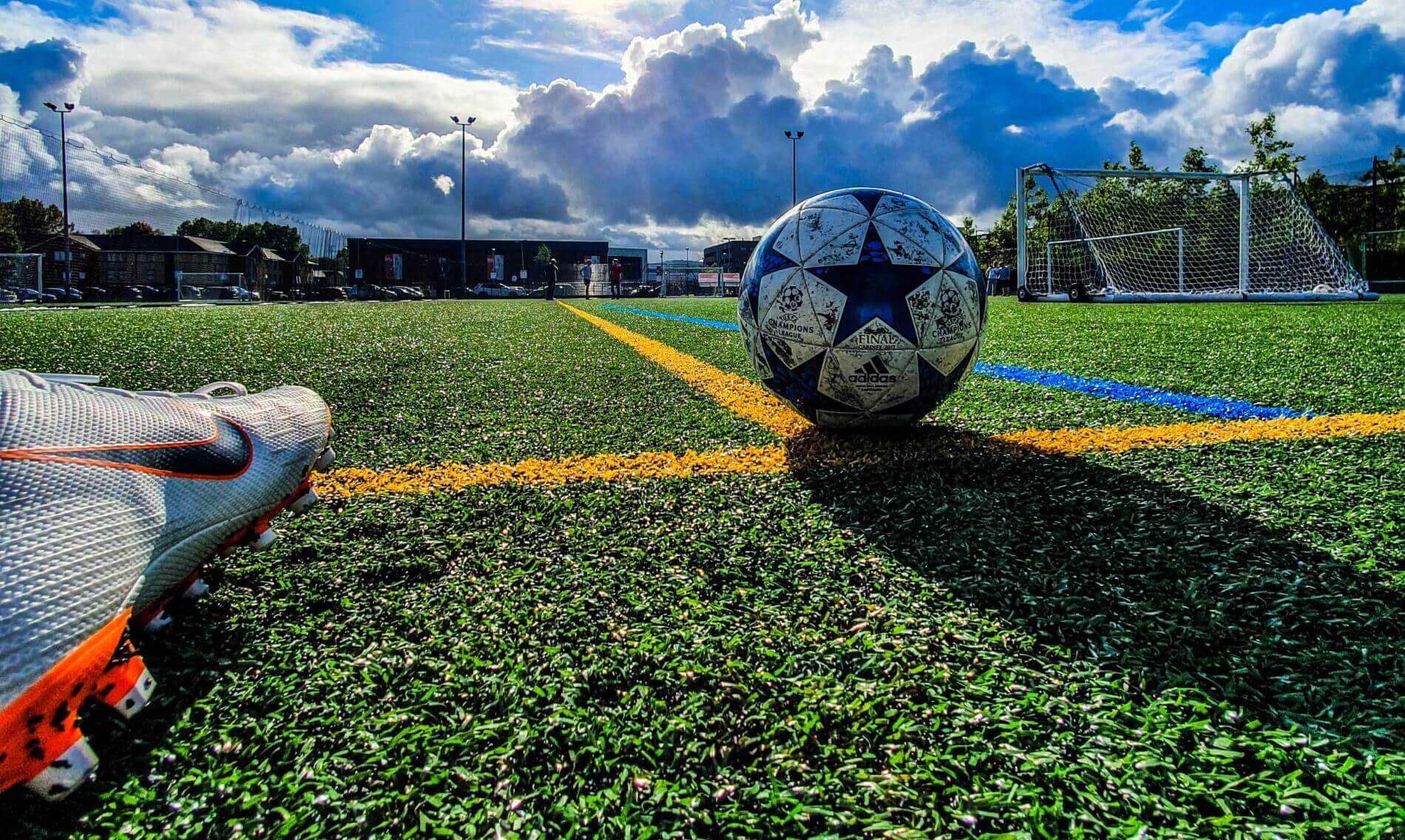 Soccer ball on field with goal in background